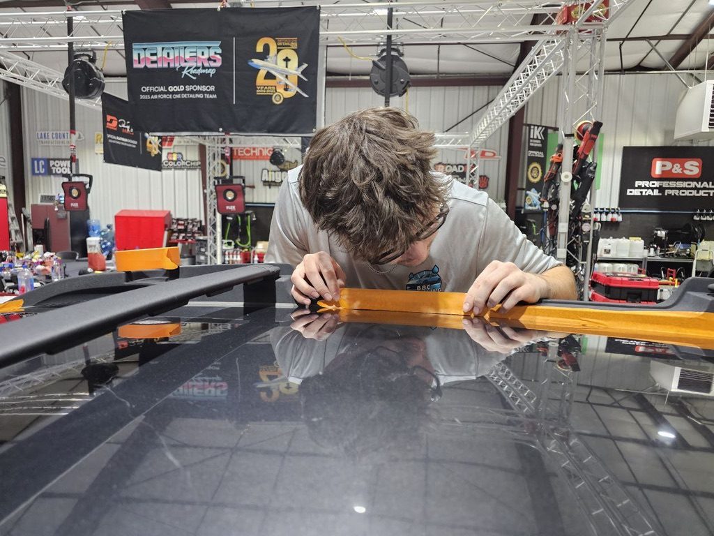 Masking roof trim before polishing at Detailing Success training, Blue Badge Customs mobile detailing in Lawrence, Kansas