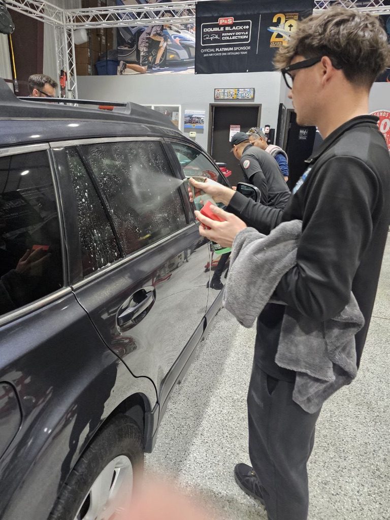 Cleaning the windows of an SUV at Detailing Success training, Blue Badge Customs mobile detailing in Lawrence, Kansas