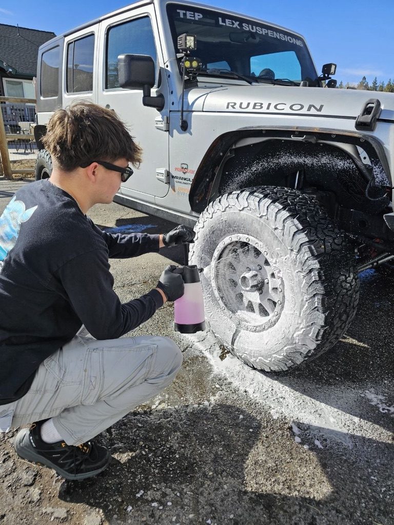 Foaming the wheels of a Jeep Wrangler Rubicon at Detailing Success training, Blue Badge Customs mobile detailing in Lawrence, Kansas