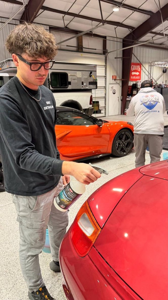 Spraying down a red sports car at Detailing Success training, Blue Badge Customs mobile detailing in Lawrence, Kansas
